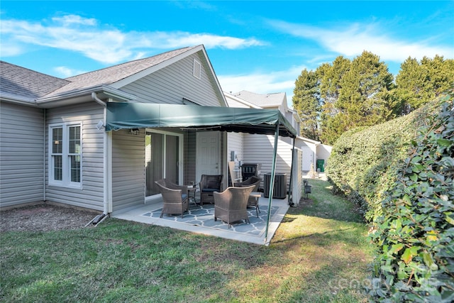 rear view of property featuring a lawn and a patio