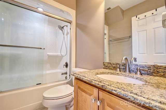 full bathroom with toilet, vanity, and shower / bath combination with glass door