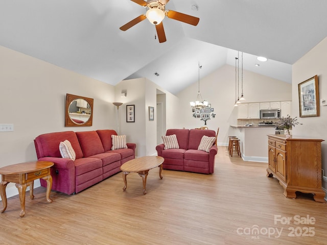 living room featuring high vaulted ceiling, ceiling fan with notable chandelier, and light hardwood / wood-style floors