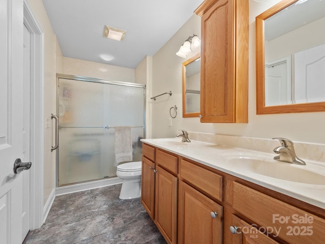 bathroom with vanity, a shower with shower door, and toilet