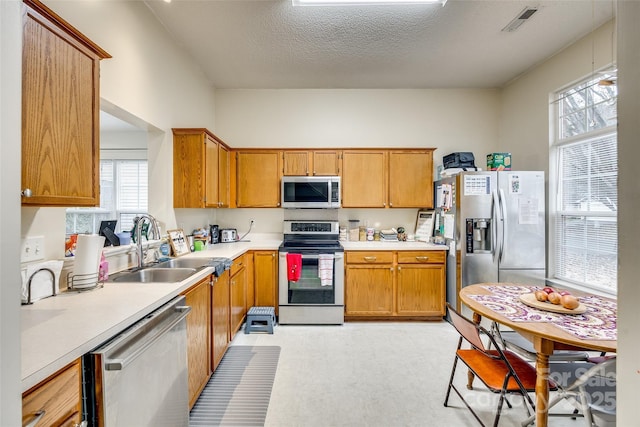 kitchen featuring appliances with stainless steel finishes, sink, and a textured ceiling