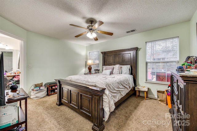 carpeted bedroom with a textured ceiling and ceiling fan