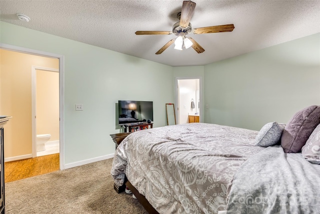 carpeted bedroom with ceiling fan, connected bathroom, and a textured ceiling