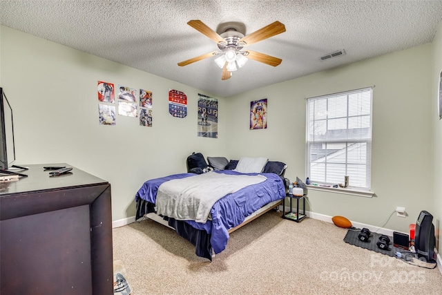 carpeted bedroom with ceiling fan and a textured ceiling