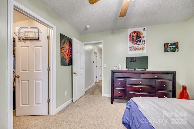 bedroom featuring ceiling fan, light carpet, and a textured ceiling