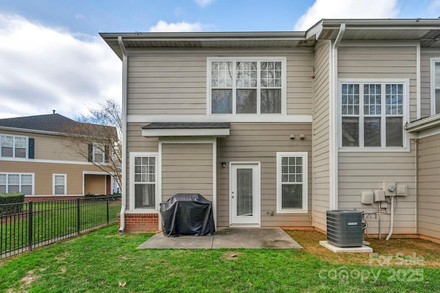 rear view of house featuring central AC unit, a patio area, and a lawn