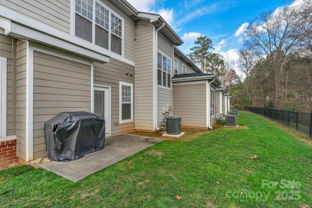 back of property featuring a yard, central AC unit, and a patio area