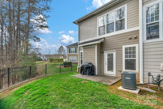 rear view of property featuring cooling unit, a yard, and a patio area