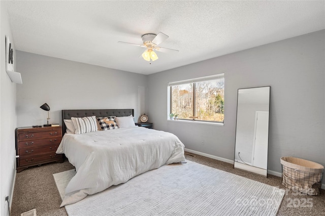 carpeted bedroom with a textured ceiling, a ceiling fan, and baseboards