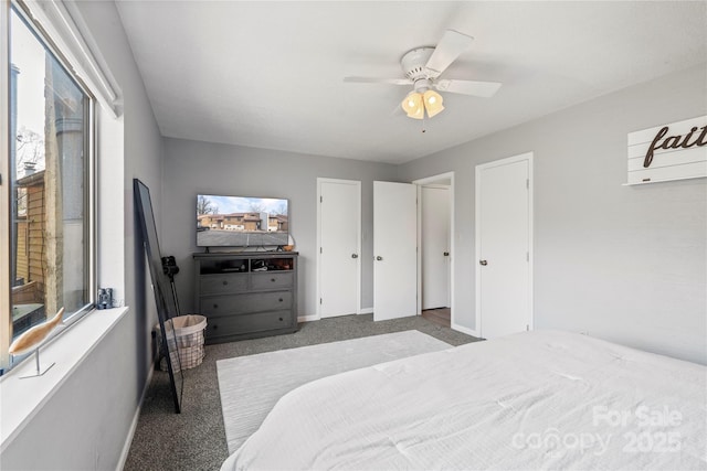 carpeted bedroom featuring multiple windows, ceiling fan, and baseboards