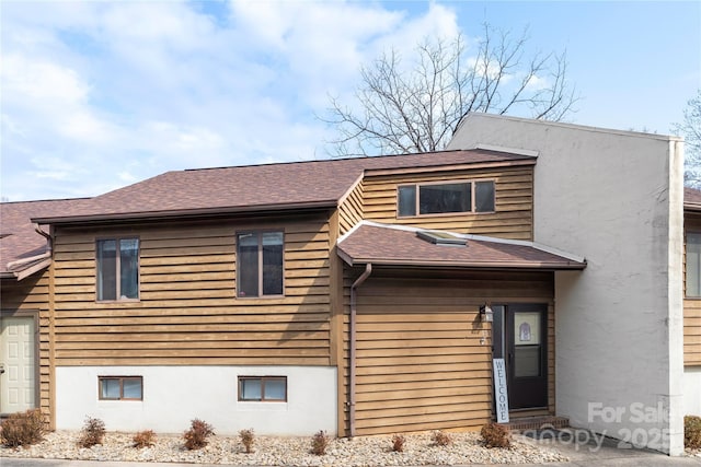 view of front of property with stucco siding and roof with shingles