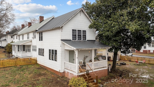 rear view of property with a sunroom and a porch