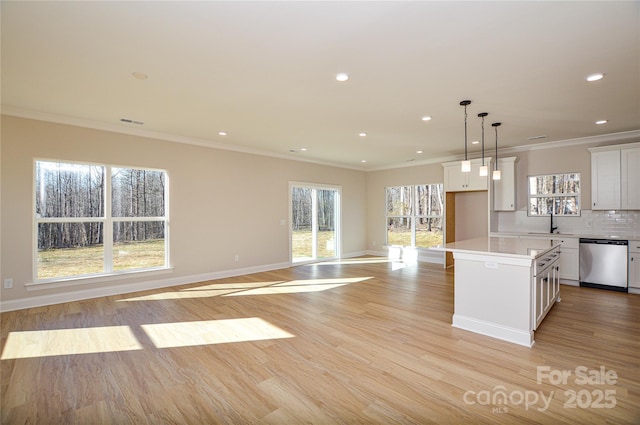 kitchen featuring tasteful backsplash, white cabinets, a sink, light wood-type flooring, and dishwasher