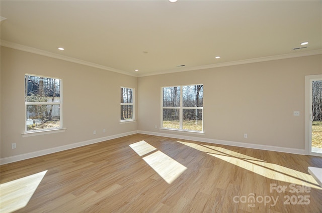 spare room featuring plenty of natural light, light wood-style flooring, baseboards, and recessed lighting