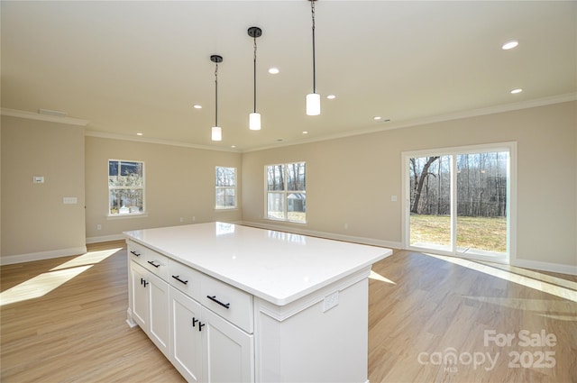 kitchen with light wood-style floors, a center island, open floor plan, and baseboards