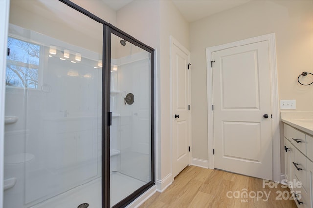 full bath with wood finished floors, vanity, and a shower stall