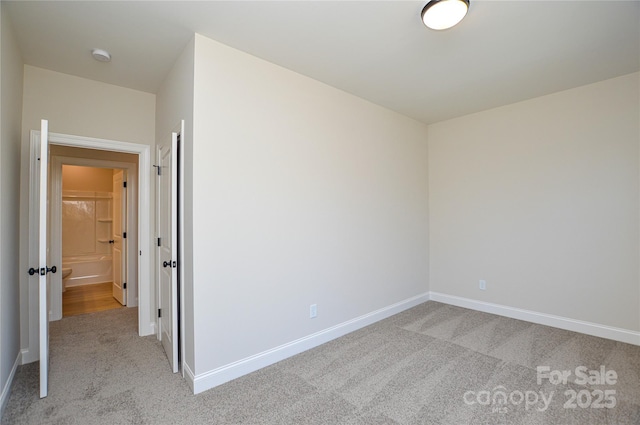 unfurnished bedroom featuring light carpet and baseboards