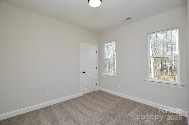 carpeted empty room with baseboards and visible vents