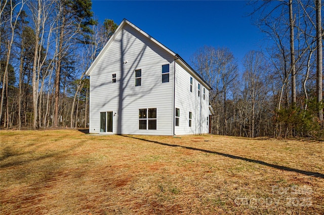 view of home's exterior with a yard and a forest view