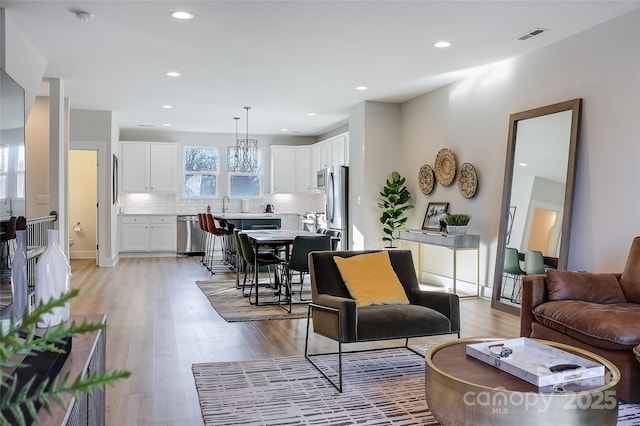 living room featuring sink and light hardwood / wood-style floors