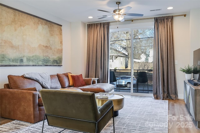 sitting room with light hardwood / wood-style floors and ceiling fan