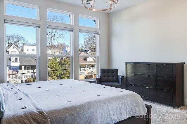 carpeted bedroom with an inviting chandelier