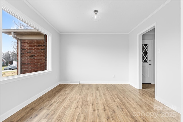 empty room featuring ornamental molding and light wood-type flooring