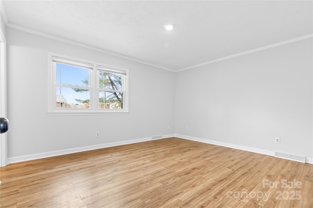 empty room with crown molding, a textured ceiling, and light hardwood / wood-style flooring