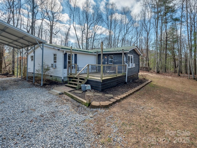 manufactured / mobile home with cooling unit, a carport, and a deck