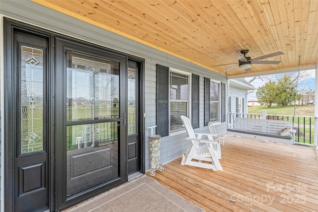 wooden deck with covered porch and ceiling fan