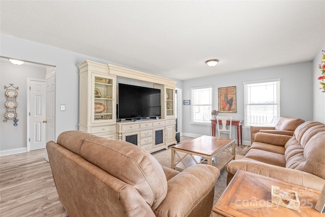 living area with light wood-style flooring and baseboards