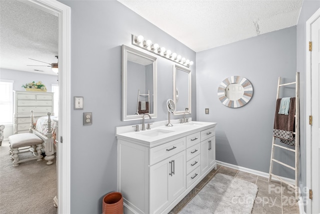 full bathroom featuring double vanity, ceiling fan, a textured ceiling, and a sink