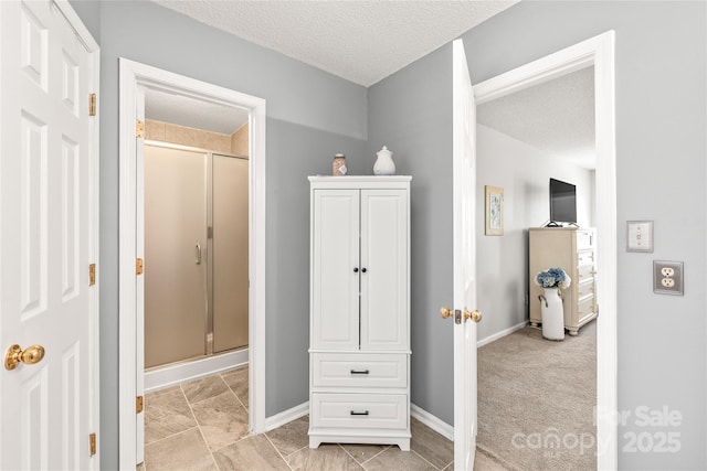 interior space with a textured ceiling and baseboards