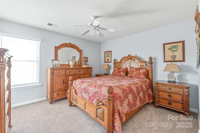 bedroom with visible vents, light colored carpet, ceiling fan, a textured ceiling, and baseboards