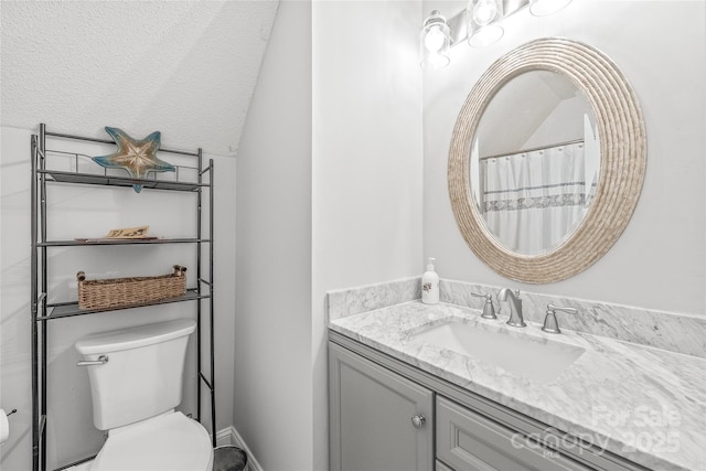 bathroom with a textured ceiling, toilet, and vanity