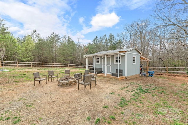 view of yard featuring an outdoor fire pit, fence, and an outbuilding