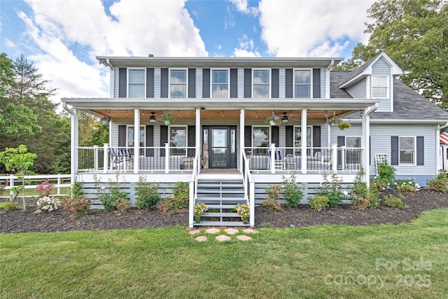 colonial home with stairway, covered porch, ceiling fan, and a front lawn