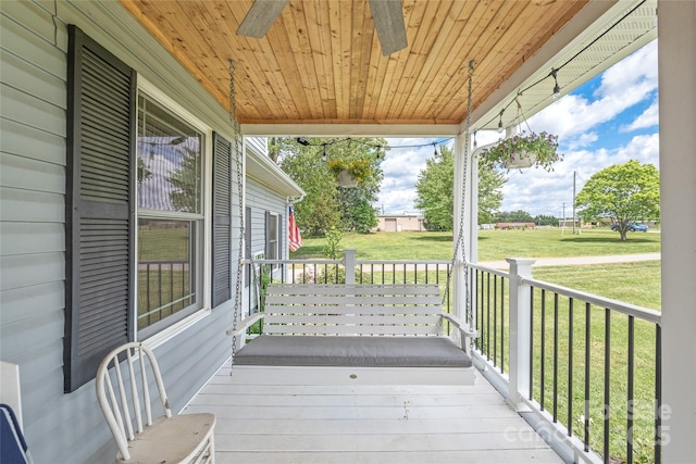 wooden terrace with a porch and a lawn