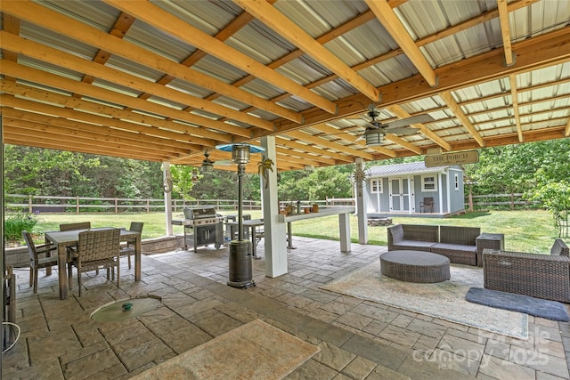 view of patio with an outdoor structure, an outdoor living space, ceiling fan, a fenced backyard, and outdoor dining space