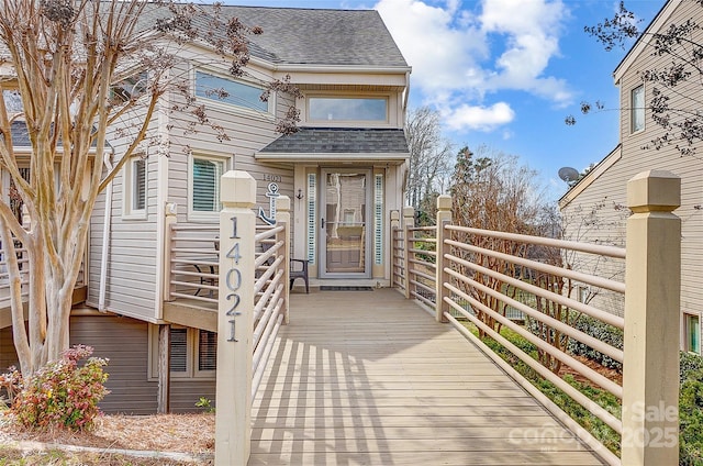 doorway to property featuring a shingled roof