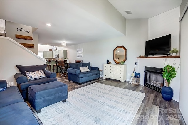 living room featuring a fireplace, visible vents, wood finished floors, and recessed lighting