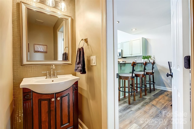 bathroom featuring wood finished floors, vanity, and baseboards