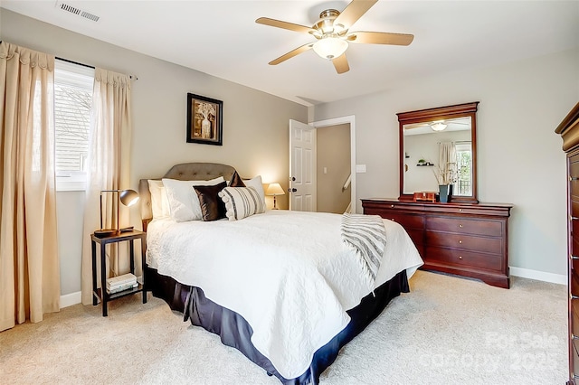 bedroom with baseboards, visible vents, and light colored carpet