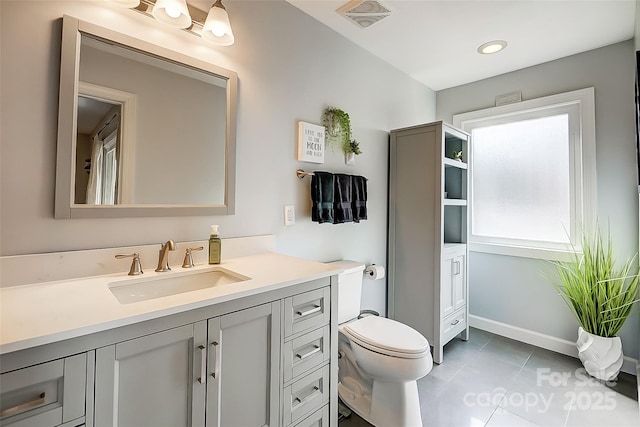 bathroom featuring baseboards, visible vents, toilet, tile patterned floors, and vanity