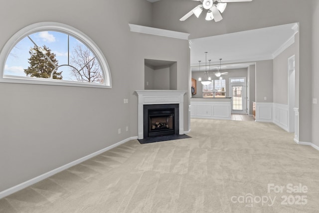 unfurnished living room featuring light colored carpet and ceiling fan