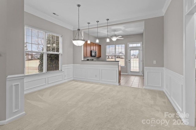 interior space featuring crown molding, ceiling fan, and light carpet