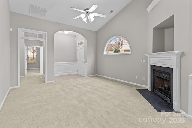 unfurnished living room featuring high vaulted ceiling, light colored carpet, and ceiling fan