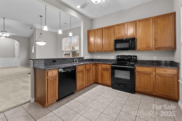 kitchen with pendant lighting, sink, dark stone countertops, ceiling fan, and black appliances