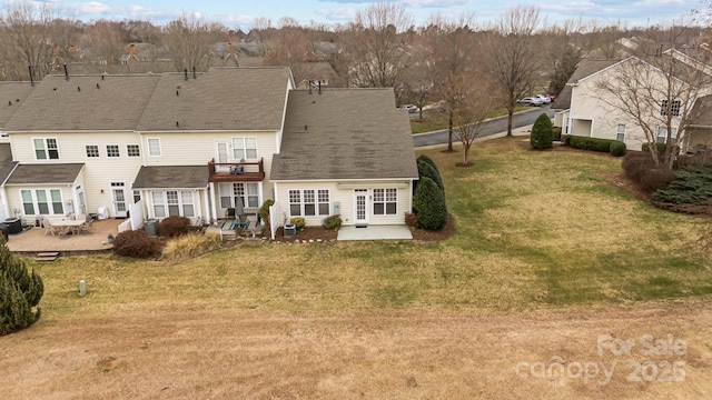 rear view of property with a balcony, a patio, and a lawn