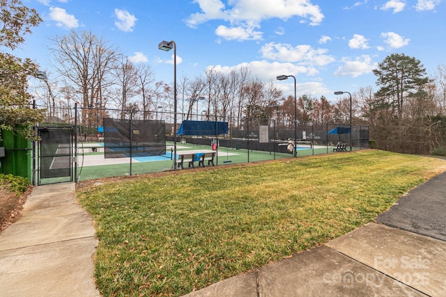 view of sport court featuring a lawn